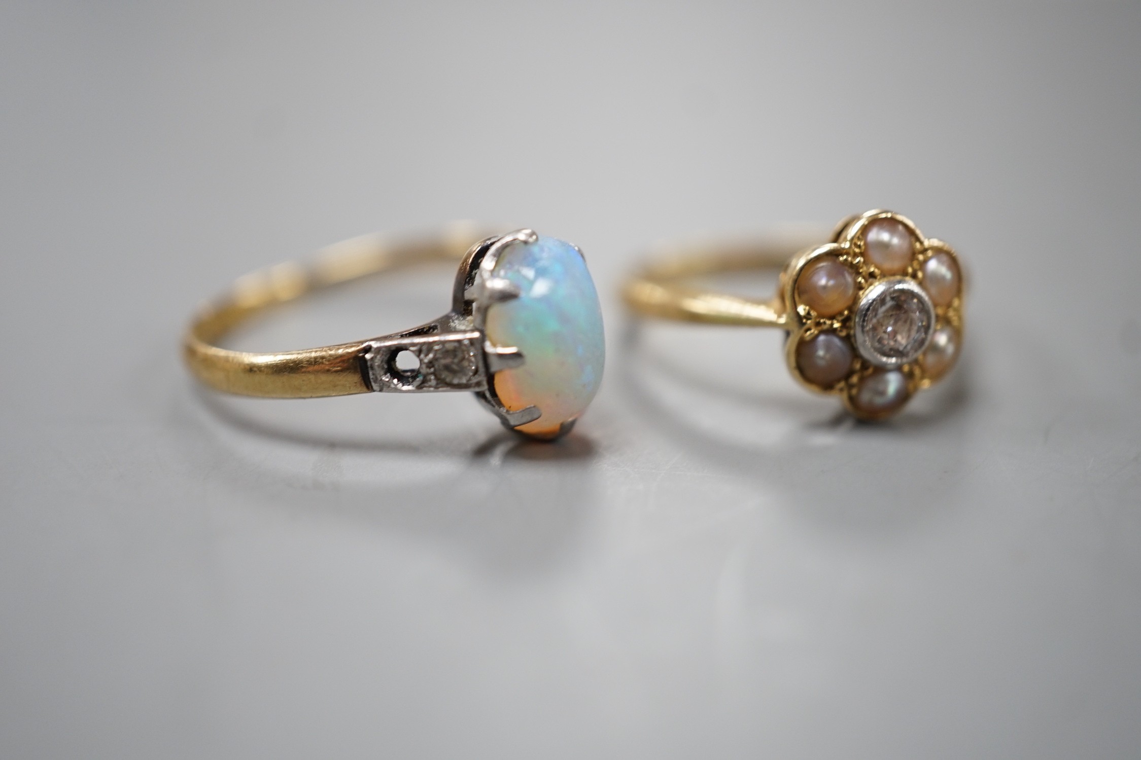 An 18ct and Plat, split pearl and diamond cluster set ring, size F/G and a similar white opal set ring with diamond set shoulders, size L, gross weight 4 grams.